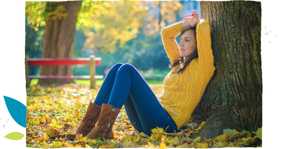 A woman in yellow sweater, sitting under the tree